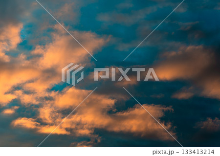 Dramatic sky with orange and blue clouds at sunset. The vibrant colors of the clouds create a stunning and captivating display in the sky. Atmospheric evening skyline. Abstract moody twilight scene. Dramatic sky with orange and blue clouds at sunset. The vibrant colors of the clouds create a stunning and captivating display in the sky. Atmospheric evening skyline. Abstract moody twilight scene. 133413214