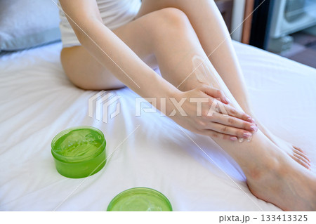 ベッドでボディジェルを脚に塗る下着姿の若いスレンダーな女性 スキンケア フットケア ベッドでボディジェルを脚に塗る下着姿の若いスレンダーな女性 スキンケア フットケア 133413325