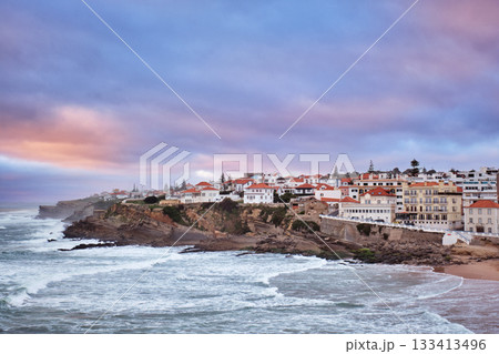 Beautiful sunset at Praia das Macas beach in Portugal. The village overlooks the ocean with colorful skies, creating a picturesque scene of natural beauty and serenity. 133413496