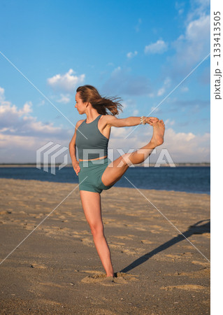 Woman yoga practice at the beach in Utthita Hasta Padangusthasana Extended Hand-to-Big-Toe Pose pose Woman yoga practice at the beach in Utthita Hasta Padangusthasana Extended Hand-to-Big-Toe Pose pose 133413505
