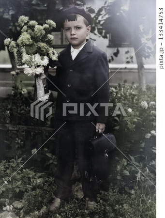 A vintage portrait of a Soviet boy with flowers and a school bag. The beginning of the school year. First time in first grade. Retro photo from 1967. A vintage portrait of a Soviet boy with flowers and a school bag. The beginning of the school year. First time in first grade. Retro photo from 1967. 133414753