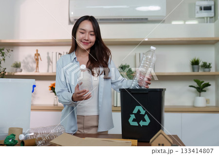 Recycling. Woman sorting plastic bottles into recycling bin, promoting eco-awareness. Recycling. Woman sorting plastic bottles into recycling bin, promoting eco-awareness. 133414807