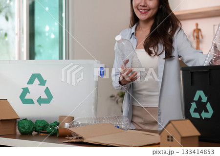 Sustainability. Woman recycling plastic bottles and cardboard in eco-friendly home. Sustainability. Woman recycling plastic bottles and cardboard in eco-friendly home. 133414853