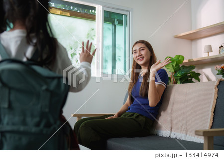 Cheerful Goodbye. Mother smiling as child waves before school. 133414974