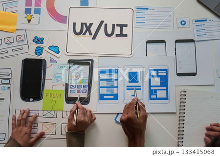 Collaborative UX UI Design. Team members working on mobile app wireframes and user interface. 133415068