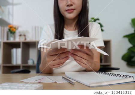 Financial Stress. Young woman reviewing bills and feeling overwhelmed at home office. Financial Stress. Young woman reviewing bills and feeling overwhelmed at home office. 133415312