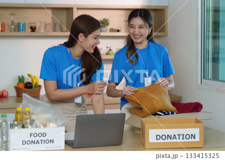 Donation. Volunteers collaborating on clothing items for charity. 133415325