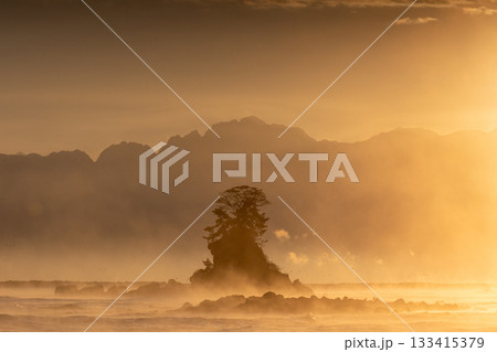 朝日の光に包まれる女岩 133415379