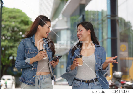 Urban Friendship. Two young women chatting and enjoying coffee in a city. Urban Friendship. Two young women chatting and enjoying coffee in a city. 133415388