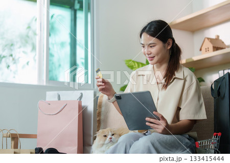 Digital Shopping. Woman using tablet and credit card for online purchase with cat. 133415444