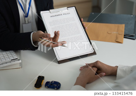 Insurance Consultation. Client discussing policy details with agent in office. Insurance Consultation. Client discussing policy details with agent in office. 133415476