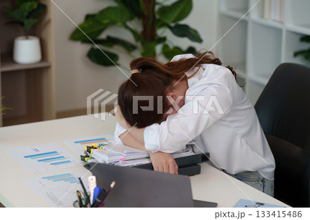 Exhaustion at Work. Young woman resting her head on her desk in frustration. Exhaustion at Work. Young woman resting her head on her desk in frustration. 133415486