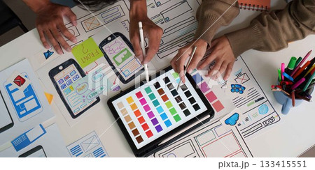 UI UX Design Collaboration. Close-up of designers selecting colors and refining wireframes. UI UX Design Collaboration. Close-up of designers selecting colors and refining wireframes. 133415551
