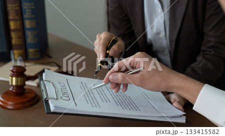 Contract Discussion. Lawyer and client reviewing a legal document together. Contract Discussion. Lawyer and client reviewing a legal document together. 133415582