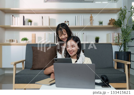 Family Connection. A mother and daughter share a digital moment while relaxing at home. 133415621