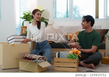 Couple organizing their new home, unpacking boxes with joy 133415712