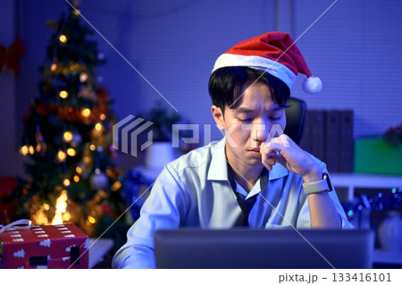 Bored, Christmas hat and portrait of a tired man in the office with a laptop, exhausted and young businessman with xmas decorations 133416101