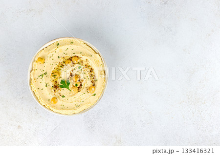Creamy lupin hummus with olive oil, herbs on white background. Top view. Copy space. Vegan protein-rich dip. 133416321