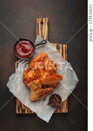 Roasted grilled chicken wings dipping sauce ketchup wooden cutting board barbecue bbq Roasted grilled chicken wings dipping sauce ketchup wooden cutting board barbecue bbq 133416822