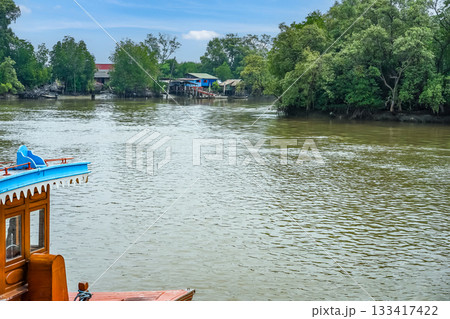 The prow of the Thai style vintage wooden boat floating on the water of a river in Hua Hin, Thailand. 133417422