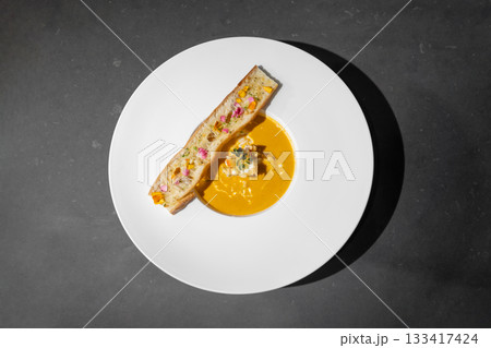 Topview Flat Lay of Garlic Bread with Creamy TomYamKung Soup on white dish in studio light, decorated with flower petal on it. Clipping Paths. Topview Flat Lay of Garlic Bread with Creamy TomYamKung Soup on white dish in studio light, decorated with flower petal on it. Clipping Paths. 133417424