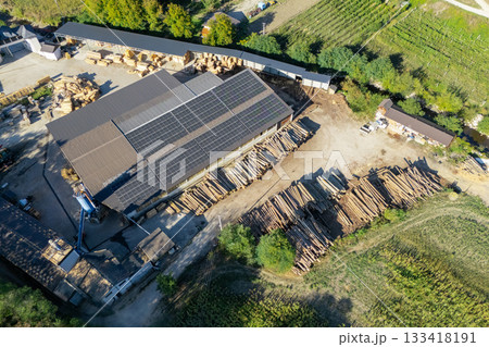 Aerial view of a sawmill factory uses renewable solar energy, with stacks of processed lumber and timber. Aerial view of a sawmill factory uses renewable solar energy, with stacks of processed lumber and timber. 133418191