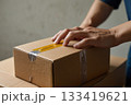 段ボール箱を開ける男性の手 133419621