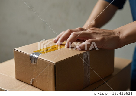 段ボール箱を開ける男性の手 133419621