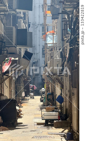 Narrow alleyway in a dense urban environment with air conditioning units 133422819