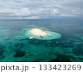Sand islet with boats anchored along clear shallow reef lagoon in open sea. Naked Island. Siargao, Philippines. 133423269