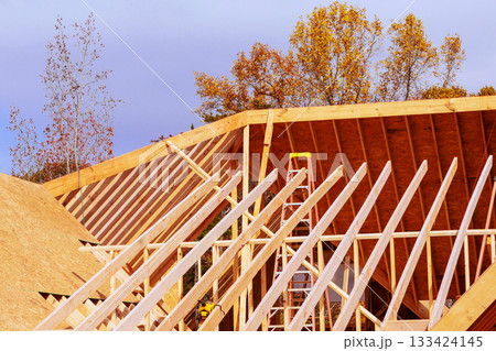 Workers are building wooden roof, house beams frame new home Workers are building wooden roof, house beams frame new home 133424145