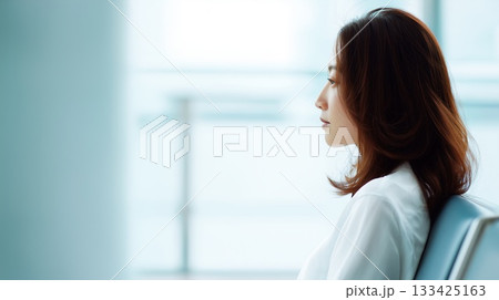 病院の椅子に座って診察を待つ日本人女性 133425163
