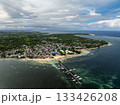 Town with coastal shoreline pier sandy beach and boats anchored near clear turquoise water. General Luna, Siargao, Philippines. 133426208