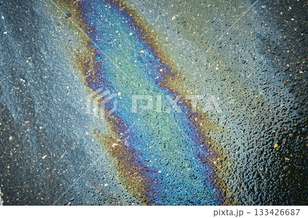 Oil Slick Reflects Light on Wet Pavement, Showcasing Vibrant Colors in an Urban Environment After Rain Oil Slick Reflects Light on Wet Pavement, Showcasing Vibrant Colors in an Urban Environment After Rain 133426687