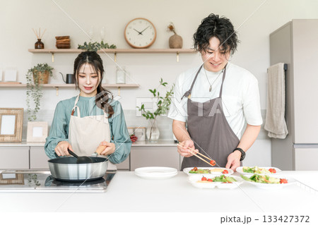 キッチンで料理をする男女・夫婦・カップル・恋人（新婚・同棲） 133427372