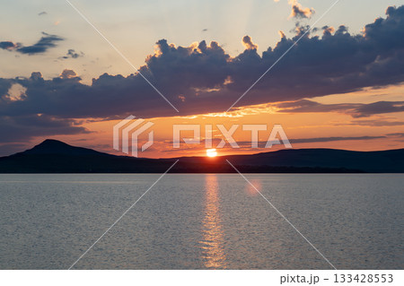 A colorful sunset over a lake among the clouds. 133428553