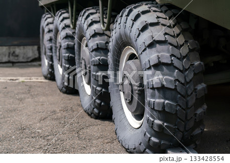 Four large black wheels of an armored vehicle with increased cross-country ability. 133428554