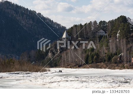 A frozen river in winter at the foot of high mountains. A frozen river in winter at the foot of high mountains. 133428703