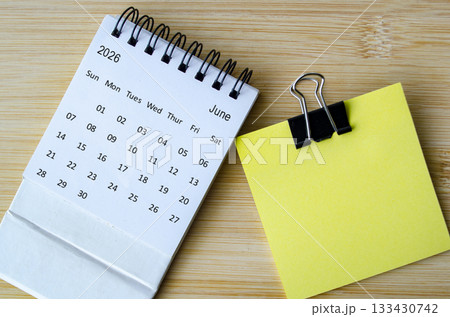 Top view of June 2026 Calendar with blank sticky note with customizable space for text or message. Top view of June 2026 Calendar with blank sticky note with customizable space for text or message. 133430742