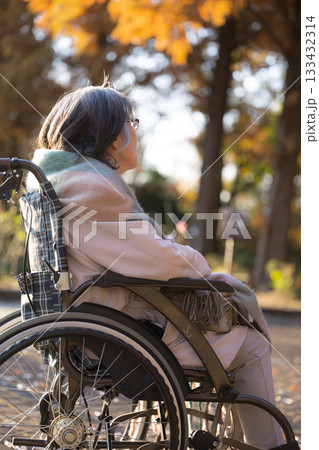 車椅子で外を見上げて微笑むシニア(高齢者)女性 車椅子で外を見上げて微笑むシニア(高齢者)女性 133432314
