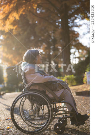 車椅子で外を見上げて微笑むシニア(高齢者)女性の写真 顔無し 車椅子で外を見上げて微笑むシニア(高齢者)女性の写真 顔無し 133432316