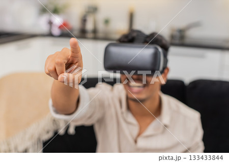 Indian man with VR headset plays game moves hands reacts smiles says wow watches online content clip 133433844