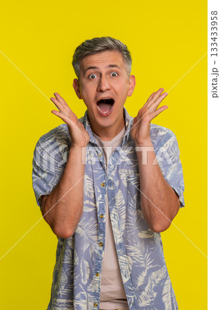Adult man shocked with hands on cheeks mouth open in disbelief showing wow emotion strong surprise 133433958