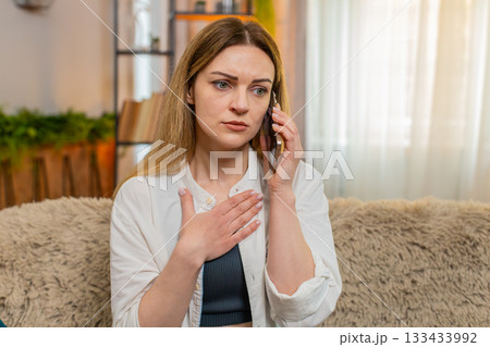 Adult woman talking on smartphone at home, reacting with sympathy concern after receiving bad news 133433992