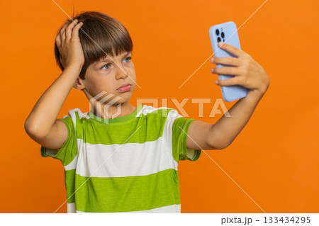 Upset sad child boy use smartphone play game loses loss fail unlucky news bad lottery result crisis Upset sad child boy use smartphone play game loses loss fail unlucky news bad lottery result crisis 133434295