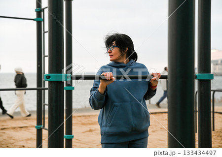 50 year old woman making vertical push ups outdoors 133434497