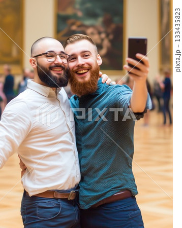 Two male friends take a joyful selfie in an art museum 133435823