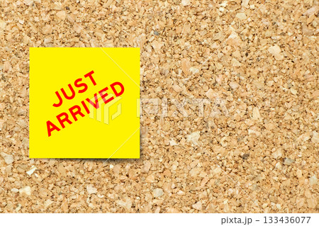 Yellow note paper with word ust arrived on cork board background with copy space 133436077