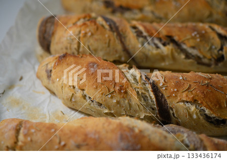 Freshly baked artisan bread loaves with a golden crust and aromatic herbs ready to be enjoyed Freshly baked artisan bread loaves with a golden crust and aromatic herbs ready to be enjoyed 133436174