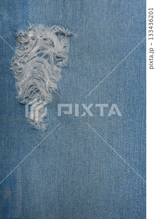 Ripped blue hipster jeans material. Destroyed denim Cloth texture. Close up. Ripped blue hipster jeans material. Destroyed denim Cloth texture. Close up. 133436201